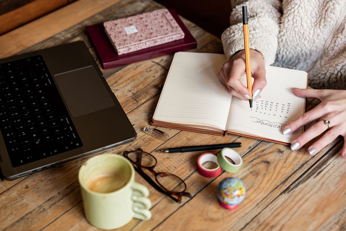 Planning a 30-day job-search action plan in a notebook beside a laptop