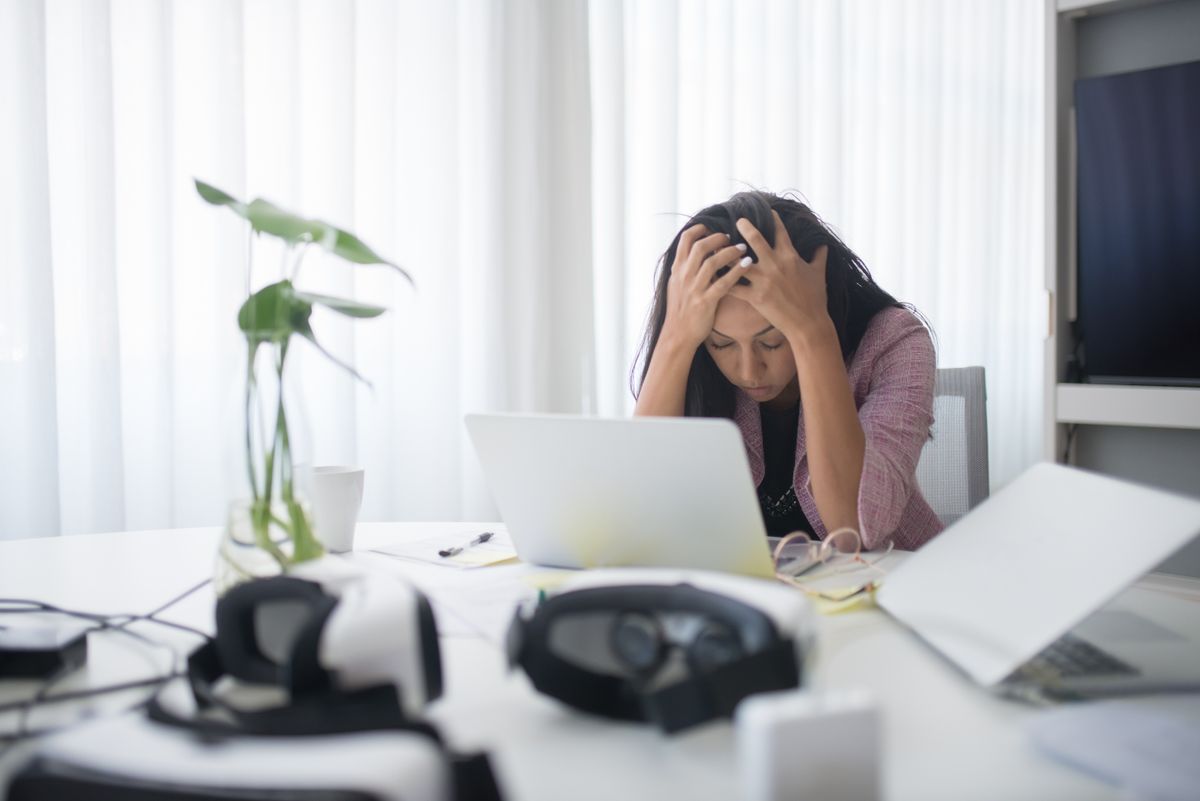 A stressed professional at her laptop weighing whether it is time for a career change